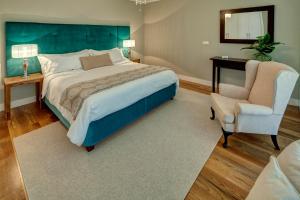 丰沙尔Number 15 Ocean & City View Villas的一间卧室配有一张大床和一把椅子