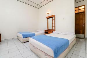 卡里乌昂Satriafi Hotel的白色墙壁客房的两张床