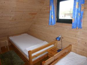 乌塞林Ferienhaeuser Auszeit am Grossen Labussee的小木屋内一间卧室,配有一张床