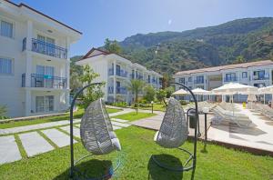 厄吕代尼兹Belcekum Beach Hotel的享有带椅子和建筑的度假村景色