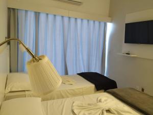 弗洛里亚诺波利斯Florinn Praia Hotel的酒店客房,设有两张床和一盏灯