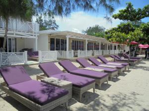 吉利美诺吉利梅诺魔度假酒店的建筑物前一排紫色躺椅