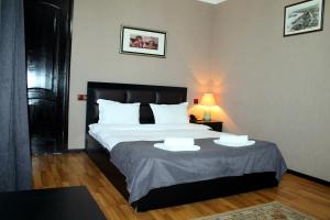 第比利斯纽麦泰基酒店的一间卧室配有一张带两个白色枕头的大床