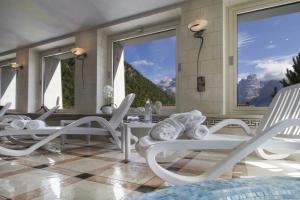 摩德纳迪-坎皮格里奥洛伦泽蒂酒店的一间设有白色椅子、桌子和大窗户的客房
