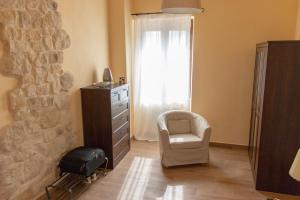 斯波莱托Alloggio turistico Montelirossi的一间卧室配有椅子、梳妆台和窗户