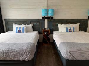 贝利斯港Beachfront Inn的两张睡床彼此相邻,位于一个房间里