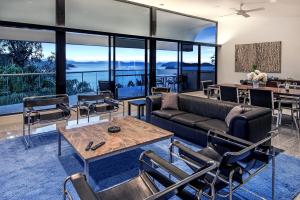 汉密尔顿岛Waves 3 Luxury 3 Bedroom Endless Ocean Views Central Location + Buggy的客厅配有沙发和桌椅
