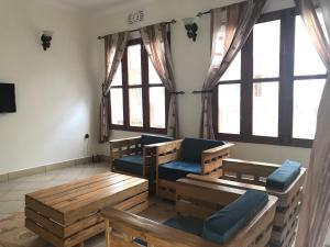 Boma la NgombeLe Parlour的客厅设有木凳和窗户。