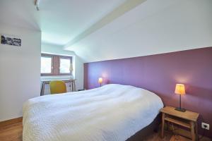 列日Gite des Coteaux的卧室配有白色的床和紫色墙壁