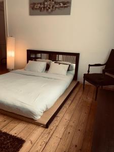 布鲁塞尔奇克科库恩住宿加早餐旅馆的卧室内的一张带白色床单和椅子的床