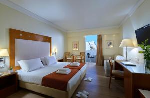 海若克利欧亚特瑞恩酒店的酒店客房设有一张大床和一张书桌。