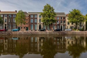 斯希丹Stadsvilla Mout Rotterdam-Schiedam的停泊在水体旁边的一座建筑物
