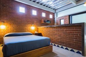 贾拉普Terraza del Alférez的一间卧室设有一张床和砖墙