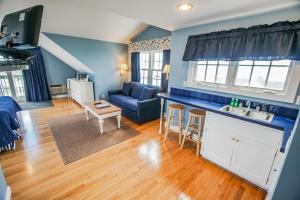 法尔茅斯Beachside Village Resort, a VRI resort的厨房以及带蓝色墙壁和木地板的客厅。