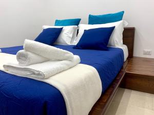 那不勒斯SECRET ROOM NAPLES historic center的一张带蓝色和白色床单及蓝色枕头的床