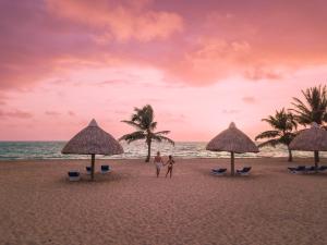 珀拉什奇亚Brisa Oceano Resort的两人站在海滩上,带遮阳伞