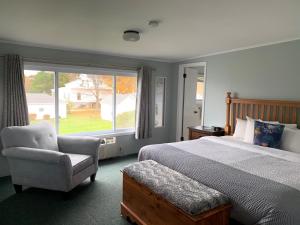贝利斯港Beachfront Inn的卧室配有床、椅子和窗户。