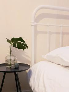 霍尔滕Appartement Plek in Holten的卧室配有白色的床和植物桌子
