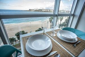 拉科鲁尼亚Apartamentos Alocea的一张餐桌,享有海滩美景