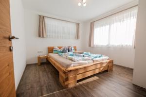 施图拜河谷新施蒂夫特Appartements Kleeblatt的一间卧室配有一张带蓝色枕头的大型木制床。