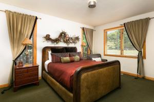 帕克城Park City Homes by White Pines Solamere的一间卧室设有一张大床和两个窗户。