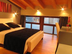 巴尔洪克拉马塔兰亚之门酒店的一间卧室配有一张床、一张书桌和一个窗户。
