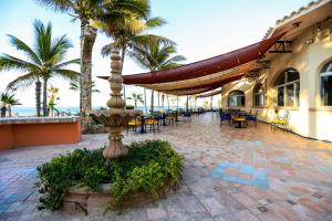雪松山Buena Vista Oceanfront & Hot Springs Resort的一个带桌椅的庭院,棕榈树