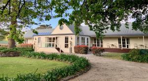 卡尔斯Glen Isla House Bed & Breakfast Phillip Island的白色的房子,设有门廊和院子