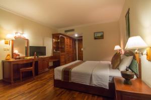 暹粒克马拉吴哥温泉酒店的一间卧室配有一张床、一张桌子和一台电脑