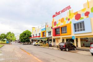 瑟古邦Blitz Hotel Batam Tanjung Uncang的一条在大楼前停放汽车的街道