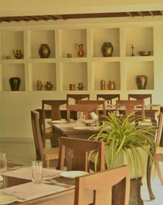 钦奈Hotel Ranjith的一间带桌椅和花瓶的用餐室