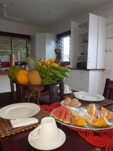 努库阿洛法黎明住宿加早餐旅馆的厨房里设有一张桌子,上面有一大堆水果