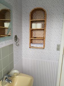 博雷Havehøjegaard的浴室设有水槽和带毛巾的架子。
