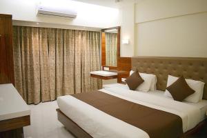 孟买米兰国际大酒店的一间卧室设有一张大床和一个窗户。