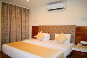 孟买米兰国际大酒店的卧室配有一张带白色床单和枕头的大床。