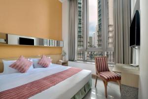 香港华逸酒店的酒店客房设有一张床、一张书桌和窗户。