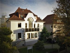 哈默尔恩Wunderschönes Penthouse im Herzen von Hameln的一间白色的大房子,有棕色的屋顶