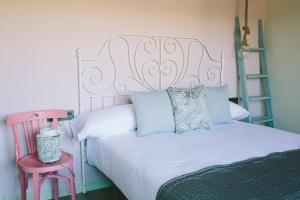 贝哈尔ALTAIR Turismo Rural的卧室配有白色的床和粉红色床头板