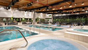 Sede Yo‘avDream Island Spa & Health Resort的一个带两个热水浴池的大型室内游泳池