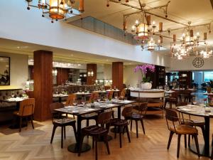 伦敦The Athenaeum Hotel & Residences的用餐室配有桌椅和吊灯。