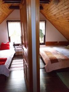 亚霍里纳Planinska kuća MAK的阁楼卧室设有两张床和两个窗户。