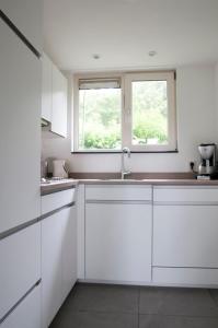 坎珀兰Zonnedauw的白色的厨房设有水槽和2扇窗户