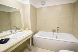 阿拉霍瓦Guesthouse likoria的带浴缸、水槽和浴缸的浴室