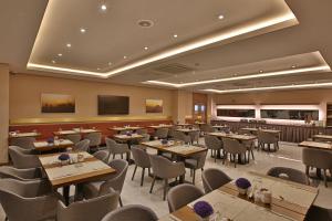 马尔丁Mardin Airport hotel的一间在房间内配有桌椅的餐厅
