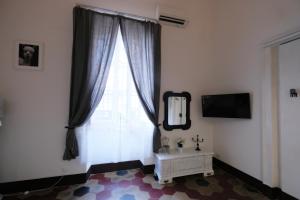卡塔尼亚a casa del reuccio的客房设有带镜子和桌子的大窗户。