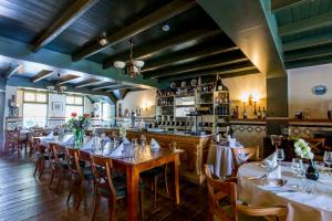 胡弗拉肯Fletcher Hotel-Restaurant De Klepperman的一间带桌椅的餐厅和一间酒吧