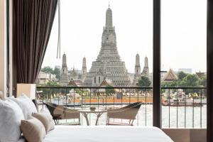 曼谷ARUN Riverside Bangkok的带一张床的客房,享有建筑的景色