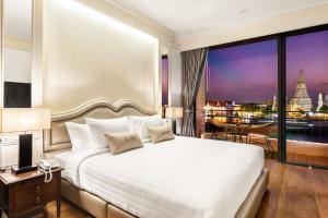 曼谷ARUN Riverside Bangkok的一间带大床的卧室,享有城市美景