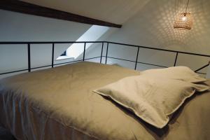 马尔什昂法梅讷Le Clocher - Résidence Le Cercle的一间卧室,配有一张带金属床头板的床