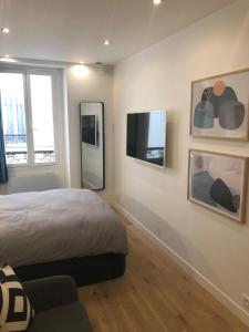 巴黎Studio design proche Champs-Elysées的一间卧室配有一张床和一台平面电视